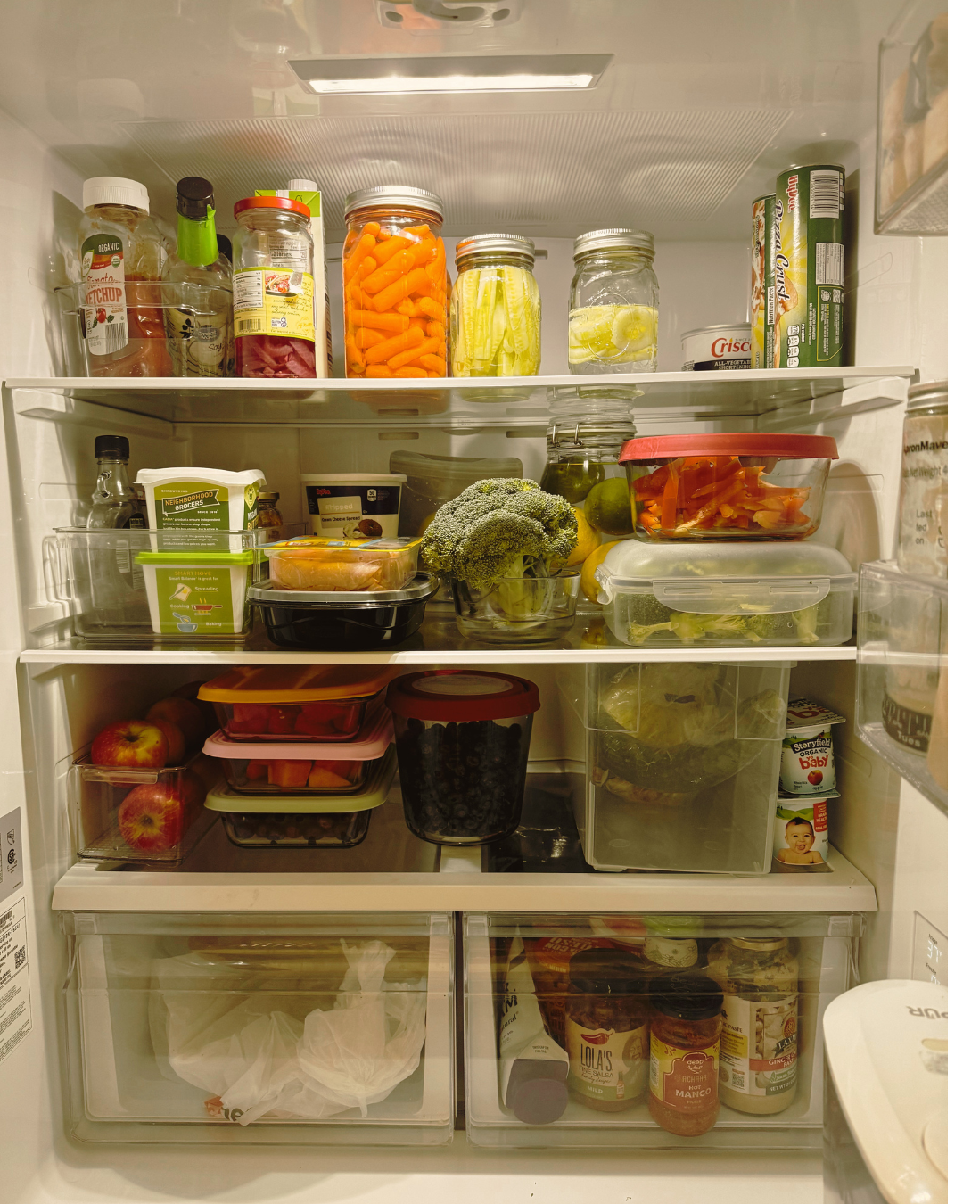 Image of inside of a fridge, with lots of fresh produce, and it is clean and organised
