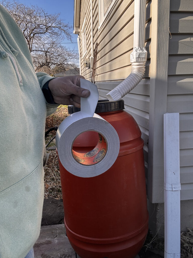 A Quick Guide to Installing a Rain Barrel - using gorilla tape to secure flexible elbow on downspout