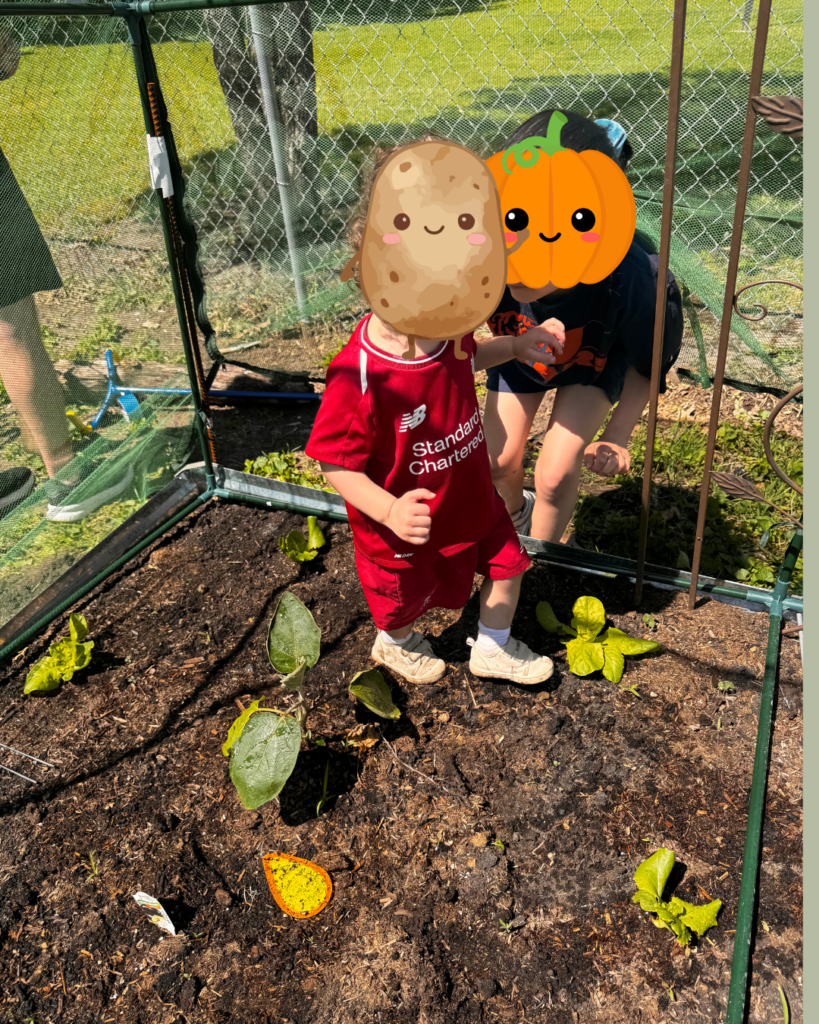 Summer rhythm - shows two children outside, standing in a raised vegetable bed