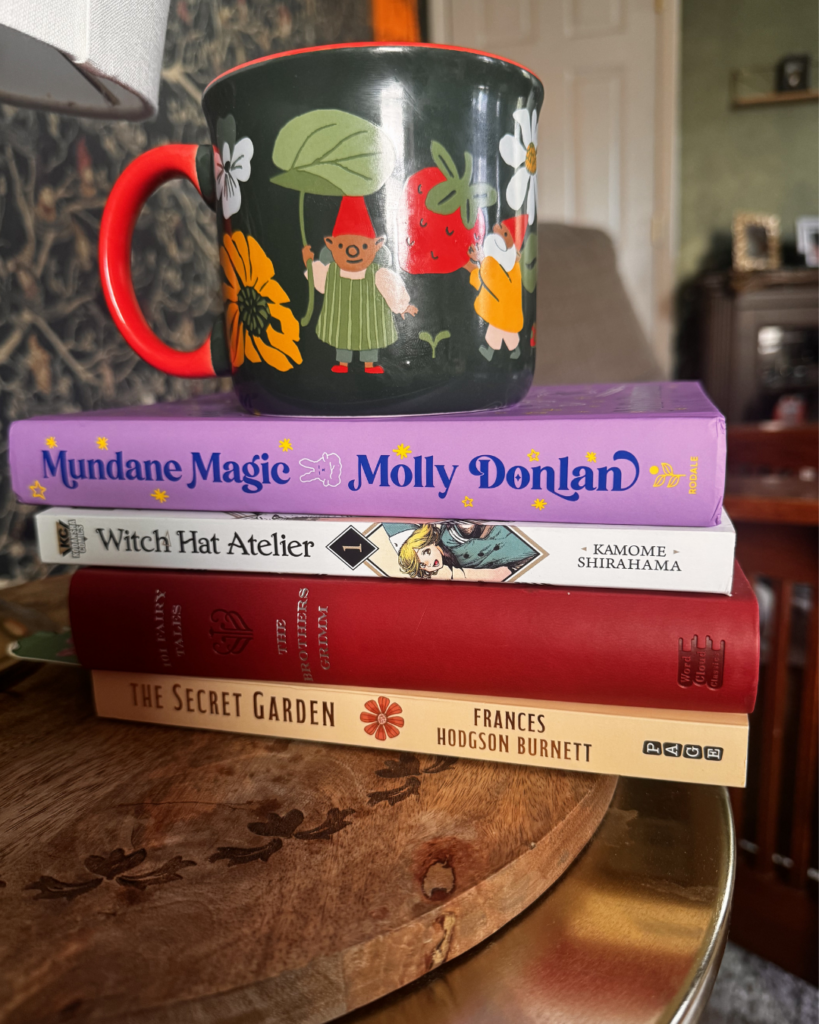 Cozy fantasy book stack with a whimsical gnome mug on a wooden table for an innkeeper lifestyle.