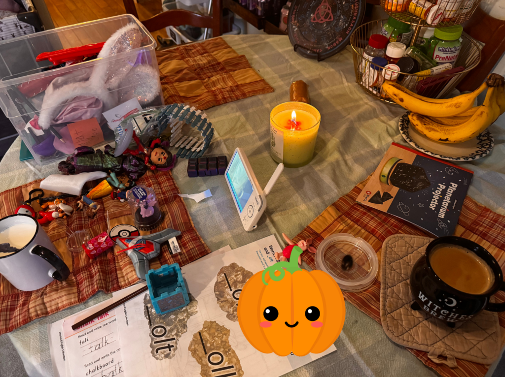 Cluttered kitchen table full of toys and mugs of warm drinks